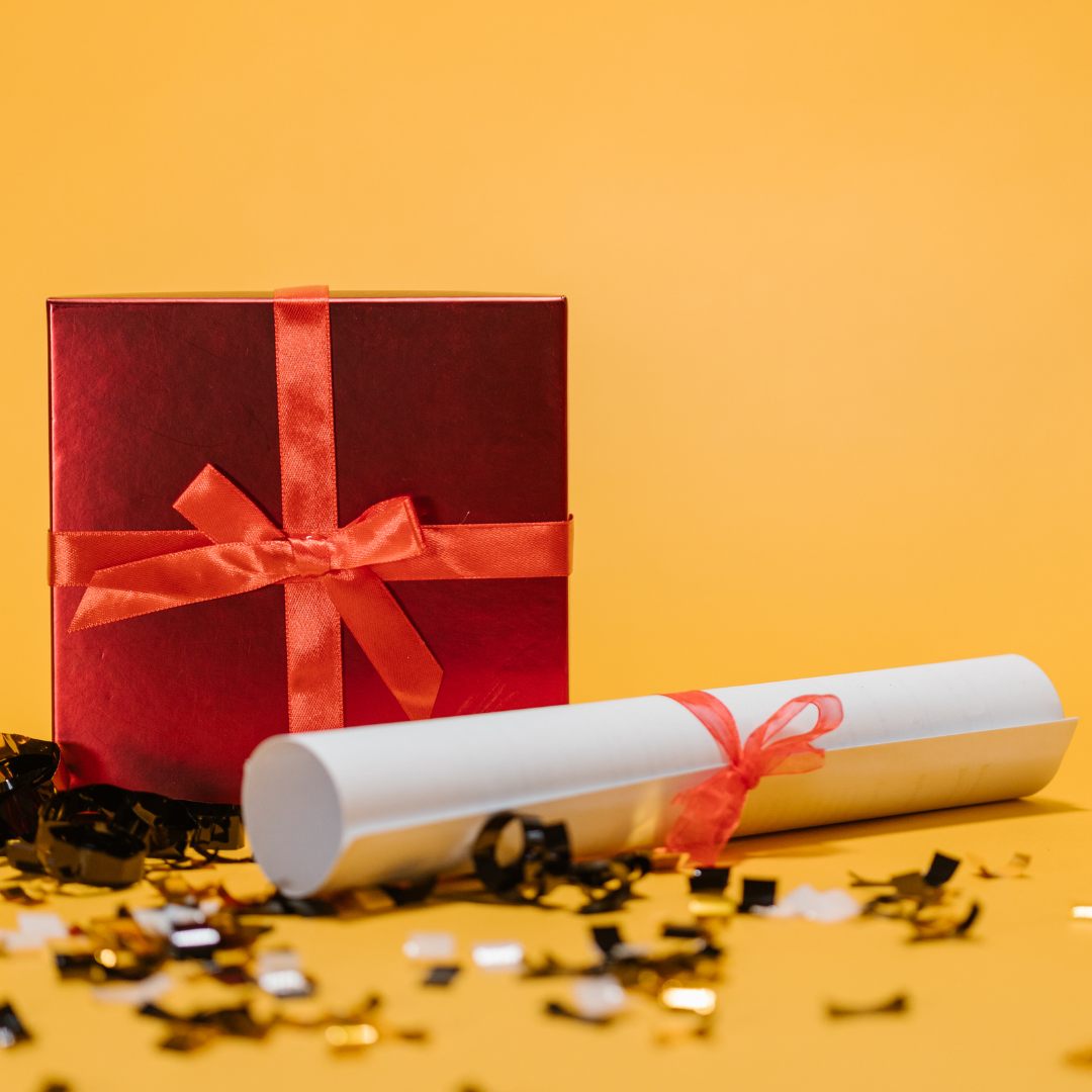 red gift box and graduate degree certificate on yellow background